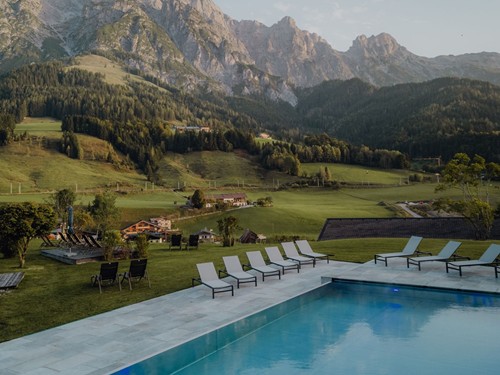 Infinity Pool mit Sonnenliegen vor markanter Felskulisse, Naturresort Puradies, Leogang, Salzburger Land Infinity Pool mit Sonnenliegen vor Bergpanorama, Puradies Leogang