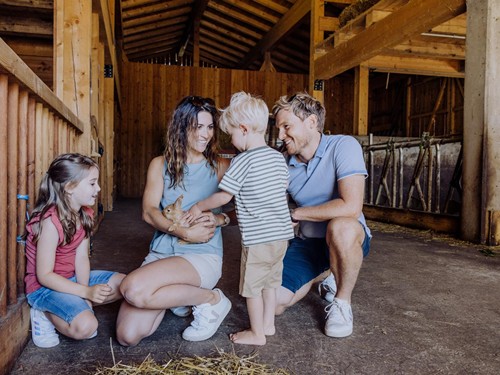 Familie mit Kaninchen im Stall des Bio-Bauernhofs Embachhof, Puradies Leogang