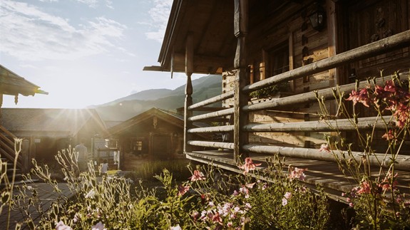 Chalets im Sommerlicht mit blühenden Blumen, Naturresort Puradies, Leogang Chalets im Sommerlicht mit blühenden Blumen, Puradies Leogang
