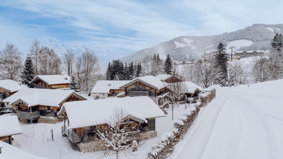 Chaletdorf im Puradies bei Schnee im Winter – Naturresort Puradies, Leogang, Salzburger Land Verschneites Chaletdorf mit Bergpanorama, Naturresort Puradies