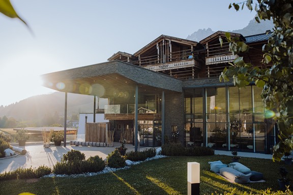 Haupteingang mit Sitzkissen im Garten bei Sonnenaufgang, Naturresort Puradies, Leogang, Salzburger Land Haupteingang mit Sitzkissen bei Sonnenaufgang, Puradies Leogang