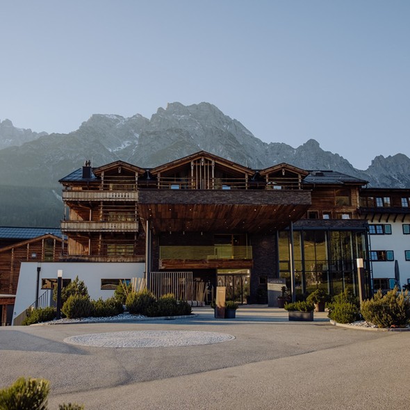 Frontansicht und Haupteingang vor Bergpanorama – Naturresort Puradies, Leogang, Salzburger Land Frontansicht und Haupteingang mit Bergpanorama, Puradies Leogang