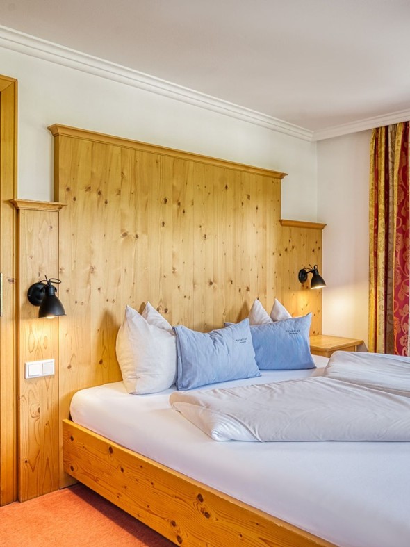 Doppelbett mit Blick ins Kinderzimmer im Genießer Familienzimmer im Naturresort Puradies