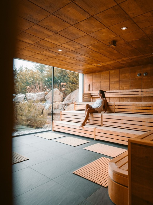 Person on the Sauna Bench Looking Outside at Heaven Spa – Naturresort Puradies, Leogang, Salzburger Land Person on sauna bench looking outside, Puradies Leogang