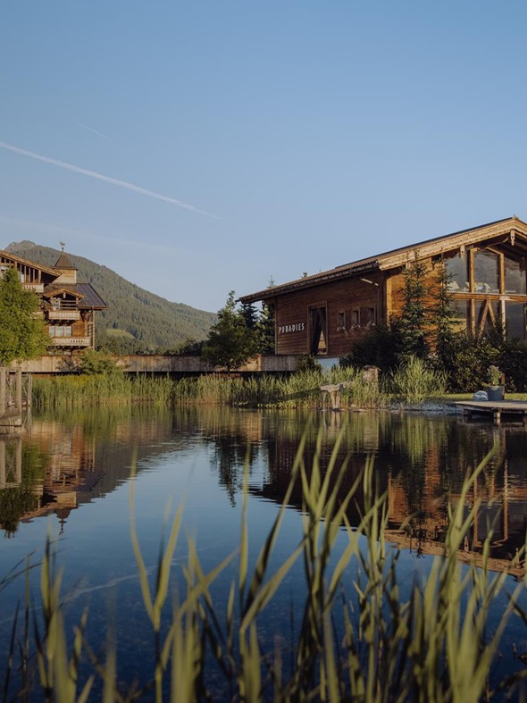 Naturbadeteich mit Traumquartier und Saunahaus im Hintergrund – Naturresort Puradies, Leogang, Salzburger Land Naturbadeteich mit Traumquartier und Saunahaus, Naturresort Puradies in Leogang