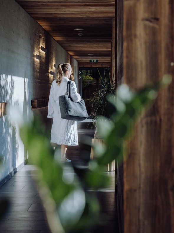 Person im Bademantel im Gang zum Adults-Only Saunahaus, Heaven Spa – Naturresort Puradies, Leogang, Salzburger Land Person im Bademantel im Gang zum Saunahaus, Puradies Leogang