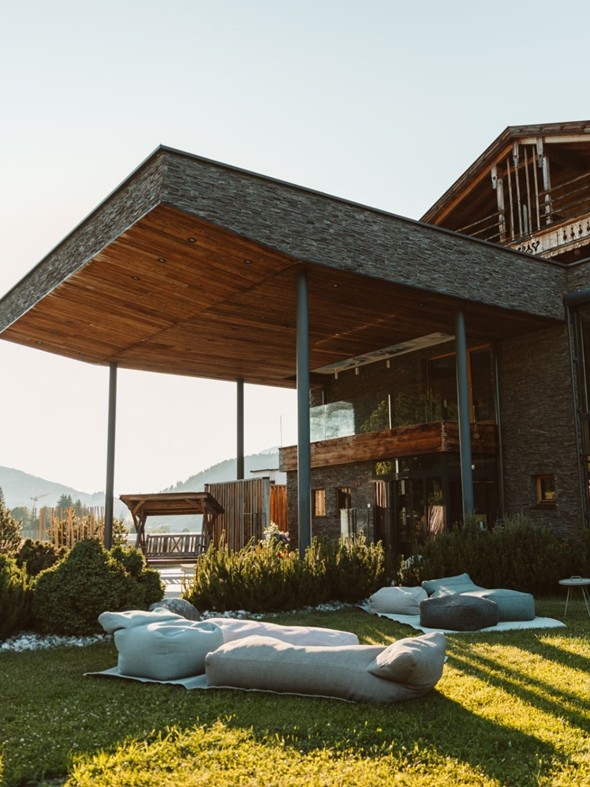 Haupteingang mit Sitzkissen im Garten bei Sonnenuntergang, Naturresort Puradies, Leogang, Salzburger Land Haupteingang mit Sitzkissen bei Sonnenuntergang, Puradies Leogang